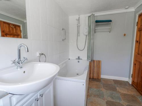 a bathroom with a sink and a bath tub at September Cottage in Weymouth