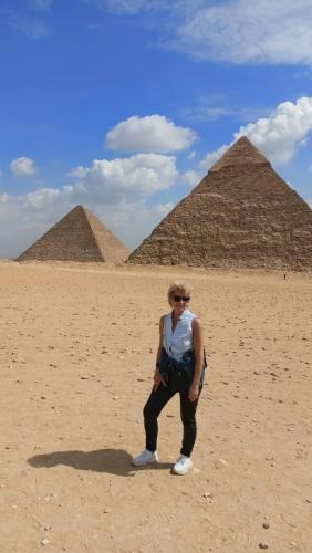 a woman standing in front of the pyramids at Families Pyramids view - Rooftop in Cairo