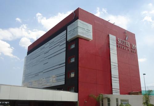 a red building with the words shuttle inn on it at Suites Inn la Muralla Hotel & Spa in Toluca