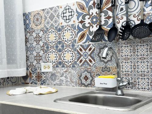 a sink in a kitchen with a tile wall at Casa Vacacional Playa del Sur in Chichiriviche