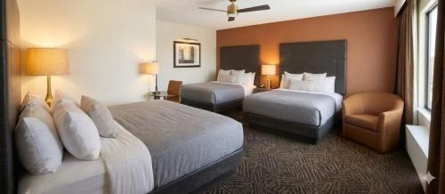 a hotel room with two beds and a chair at Quality Inn Lamar in Lamar