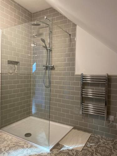 a shower with a glass door in a bathroom at The Stables Apartment in Midleton