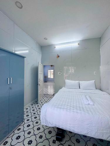 a bedroom with a large white bed and a hallway at Bắp Bơ Homestay in Cồn Giả Viên