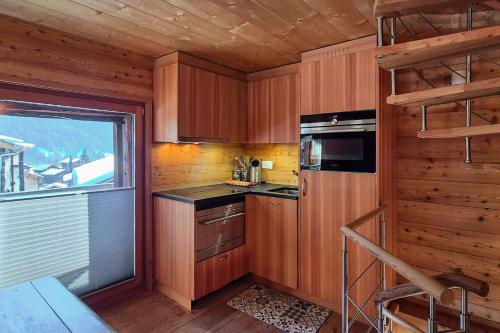 a small kitchen with wooden walls and a window at Stadel de Riedmatten in Reckingen - Gluringen