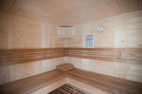 a large wooden room with a sauna with a clock at B&B Innbrugas in Bruges
