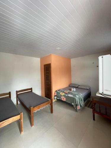 a room with two beds and a tv in it at POUSADA ORTEGA in Bodoquena
