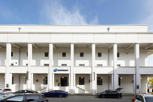 a white building with cars parked in a parking lot at Best Western ToRVEhallerne in Vejle