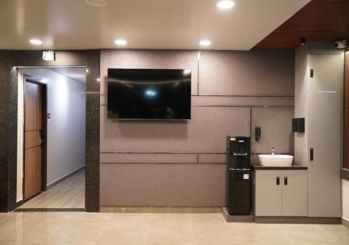a kitchen with a sink and a tv on the wall at Sri Rama Grand in Chilakalūrupet