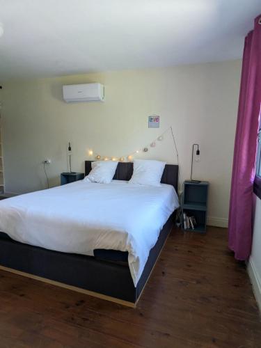 a bedroom with a large bed with lights on it at Au Marron in Seissan