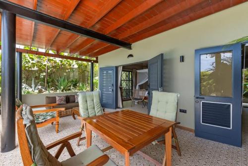 a living room with a wooden table and chairs at Bali Suites - Ubud Suite in Willemstad