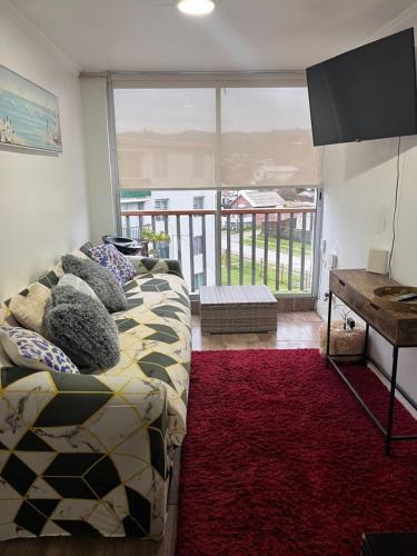 a living room with a bed and a television at Playa de Dichato in Dichato