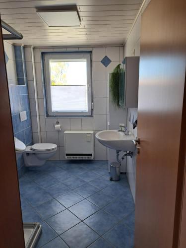 a bathroom with a sink and a toilet and a window at Gästehaus Kienle in Rot an der Rot
