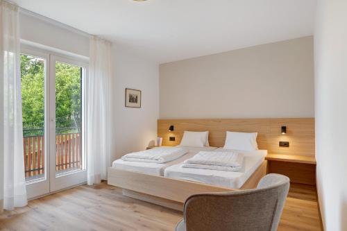 a bedroom with a bed and a balcony at Ferienappartement Freiblick in Marlengo