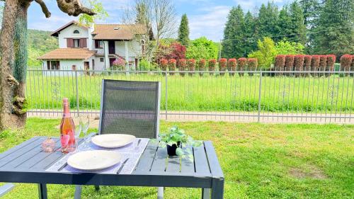 a picnic table with plates and a bottle of wine at Family 3-Bedroom Apartment near MXP & Lake Maggiore - Parking in Sesto Calende