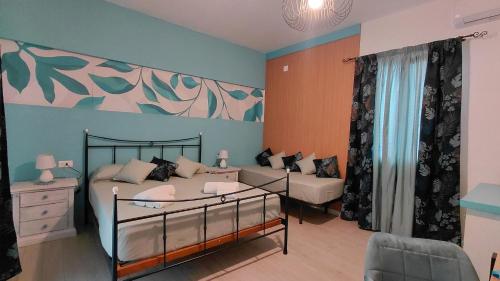 a bedroom with a bed and a couch at Sicilia Meraviglia B&B in Fontane Bianche