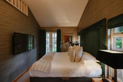 a bedroom with a large bed and a television at Grand Fir Lodge - The Hollies Retreats in Tarporley