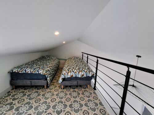 two beds sitting next to a staircase in a room at Les Bords de l'Ouin - Mauléon - Proche PuyduFou - 4 personnes in Mauléon