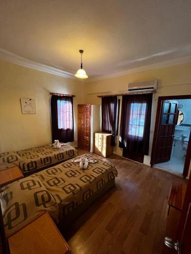 a bedroom with a bed and wooden floors and windows at Köseoğlu Apart Villa in Fethiye