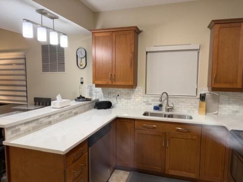 a kitchen with wooden cabinets and a sink and a window at Lakeshore Villa Estates in Osoyoos