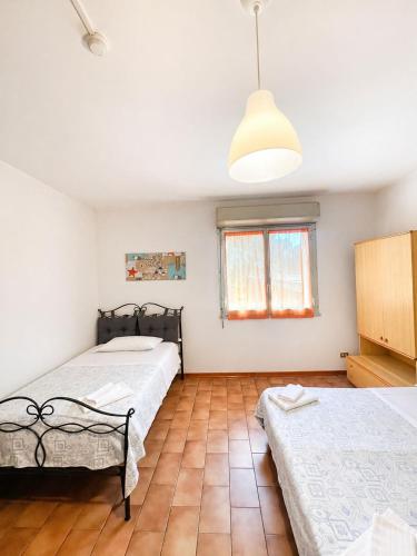 a bedroom with two beds and a pendant light at Hotel Nazionale in Milano Marittima