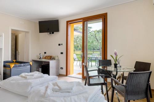 two beds in a room with a table and chairs at Casa Elisa in Torri del Benaco