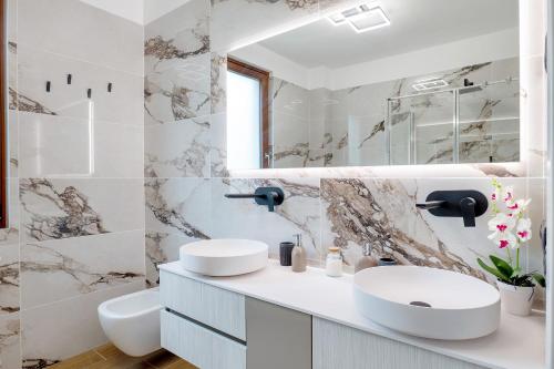 a bathroom with two sinks and a mirror at Casa Elisa in Torri del Benaco