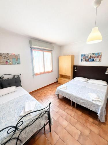 a room with two beds and a bench in it at Hotel Nazionale in Milano Marittima