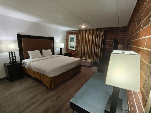 a hotel room with a bed and a brick wall at Plaza Hotel By OYO Calumet Park Alsip I 57 in Calumet Park