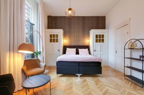 a bedroom with a bed and a chair at The Velvet Suite Alkmaar in Alkmaar