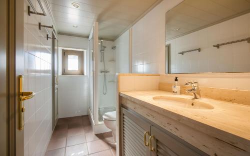 a bathroom with a sink and a toilet and a mirror at Luxury Rocamar – Primera Línea y Terraza in Tossa de Mar
