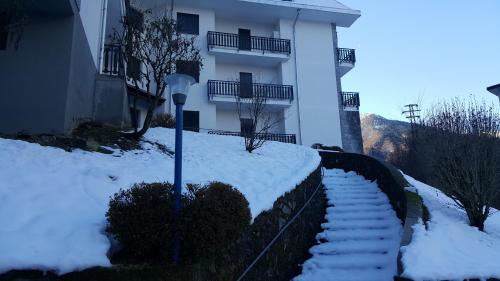 スコペッロにあるAppartamento Antaresの建物前の雪段