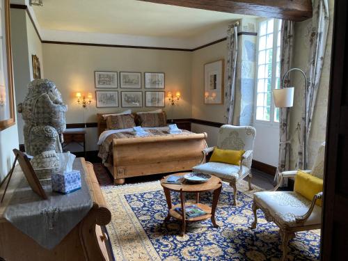 a living room with a bed and a table and chairs at Moulin de Bapaumes in Nérac