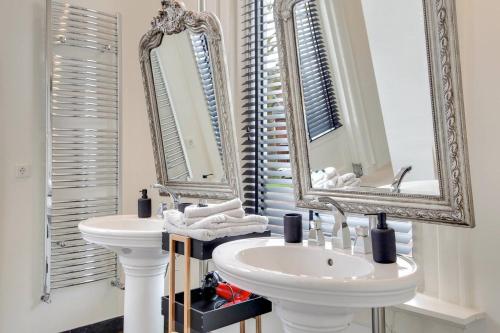 a bathroom with two sinks and two mirrors at The Velvet Suite Alkmaar in Alkmaar