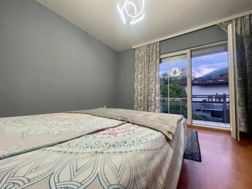 a bedroom with a bed and a large window at Cozy Home in Peje