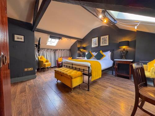 a bedroom with a king sized bed and yellow accents at The Fat Badger in York