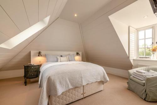 a white attic bedroom with a bed and a window at 2 Bed in Stoke oc-c41361 in Hurstbourne Tarrant