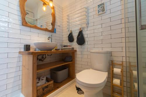 a bathroom with a toilet and a sink and a mirror at Agapito's Houses in Praia de Odeceixe