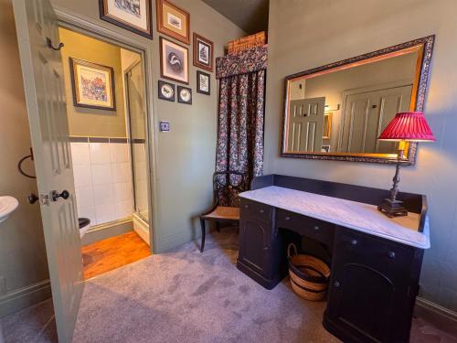 a bathroom with a vanity with a mirror and a sink at The Fat Badger in York