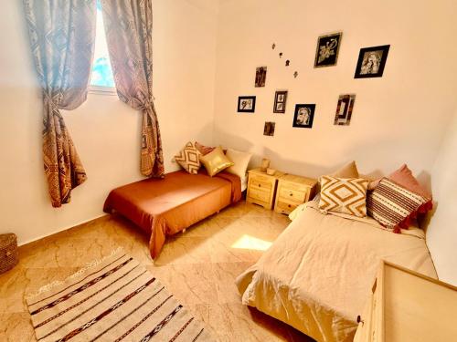 a bedroom with two beds and a window at SeArt Home by the Ocean in Aourir