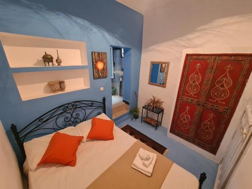 a bedroom with a bed with orange pillows on it at La Joya Hostel Chafchaouen Cozy Stay with Terrace in Chefchaouen