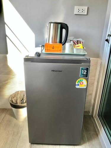 a small refrigerator with a kettle on top of it at กบอุทัย รีสอร์ท in Ban Don Khwang