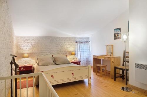 a bedroom with a bed and a desk in it at Gîte Le Gué De Champagné in Torxé