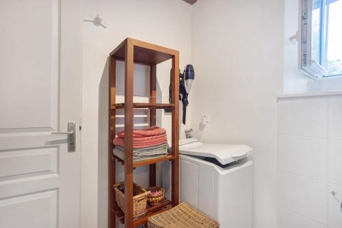 a bathroom with a wooden towel rack next to a sink at Gîte Le Gué De Champagné in Torxé