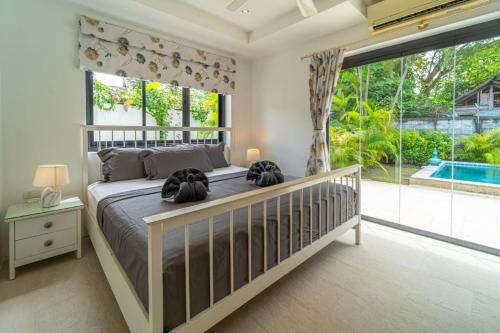 a bedroom with a large bed and a large window at Malee Beach F1 in Phra Ae beach