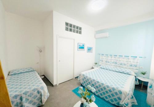 a bedroom with two beds and a table at La Pavoncella in Oristano