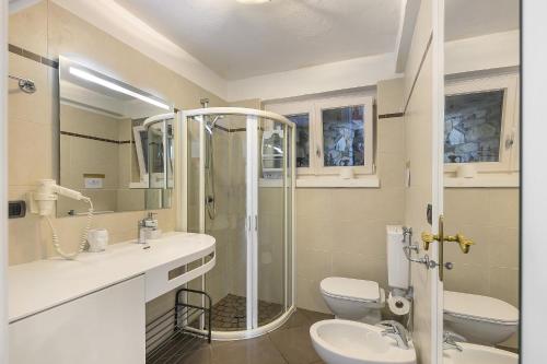 a bathroom with a shower and a toilet and a sink at Residence La Mignon Oleandri in Torri del Benaco