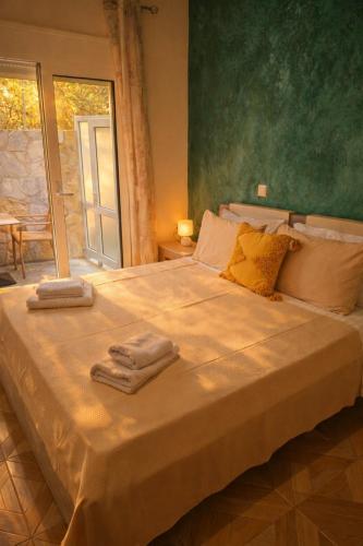a bedroom with a large bed with towels on it at Dagos Rooms in Dhërmi