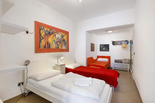 a bedroom with two beds and a red couch at Residence La Mignon Oleandri in Torri del Benaco