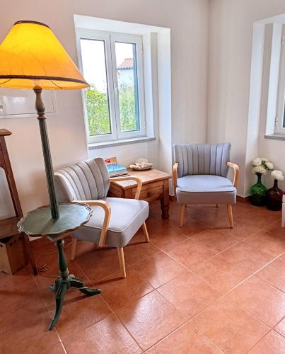 a living room with a lamp and a chair at Casa da Lameira in Vilar do Ruivo