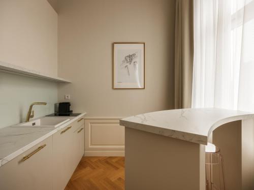 a white kitchen with a sink and a counter at Hotel Traugutta 12 in Łódź